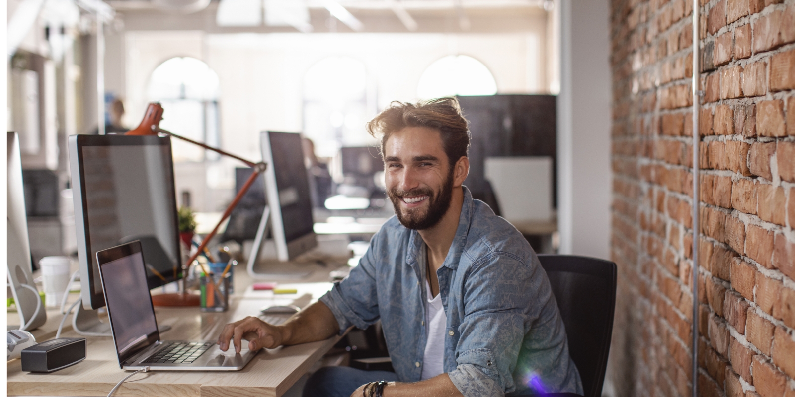 Homme souriant travaillant en open space